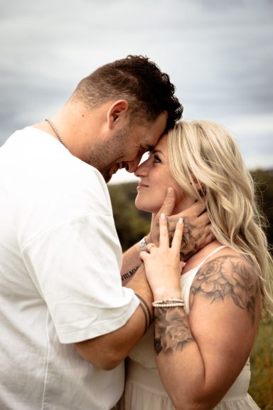 Ein Paar steht sich nahe gegenüber, lächelt und blickt sich in die Augen.